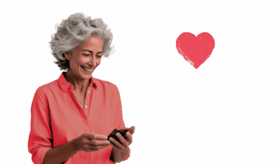 Foto einer Frau mit hellroter Bluse und grauen Haaren, lachend, mit Smartphone