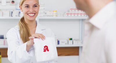 Hochwertige Apothekerin in der Apotheke, die Medikamente und Gesundheitsprodukte für Operationen bereitstellt, freundliche Beratung, Startseite, mein.apotheken.de.