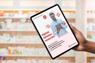 Apotheker zeigt auf Tablet mit digitaler Apotheken-Info in einer Apotheke, Fokus auf digitale Gesundheitslösungen und Medikamenteninformationen.
